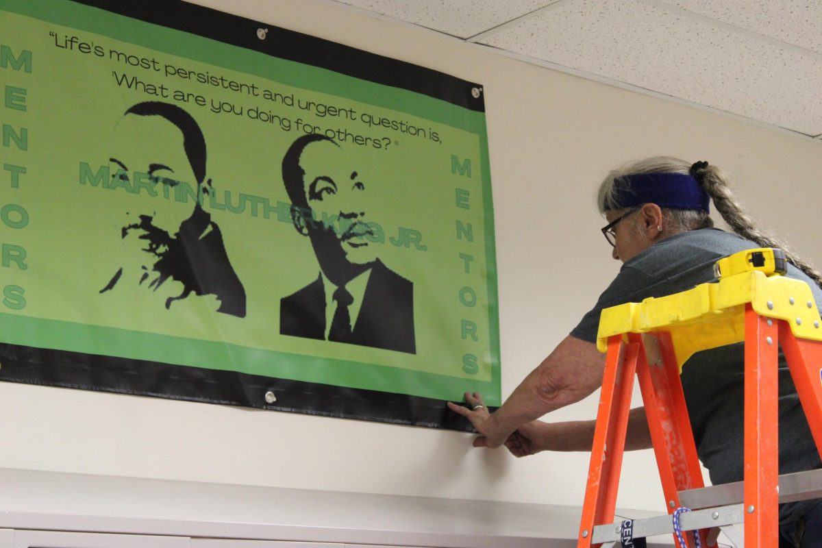 Mary King hangs a new sign in the hallway prior to PRE-MED on August 1st. Mary and the entire custodial staff spend a lot of time working hard over the summer cleaning up the school and getting it ready for the new school year. 